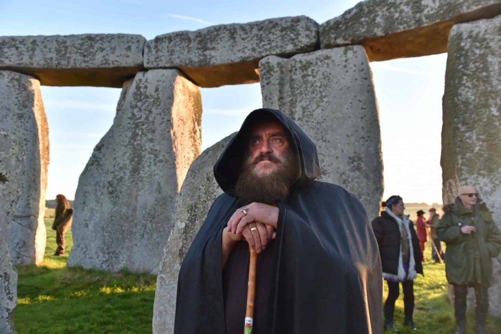 a man dressed up as a druid at stonehenge